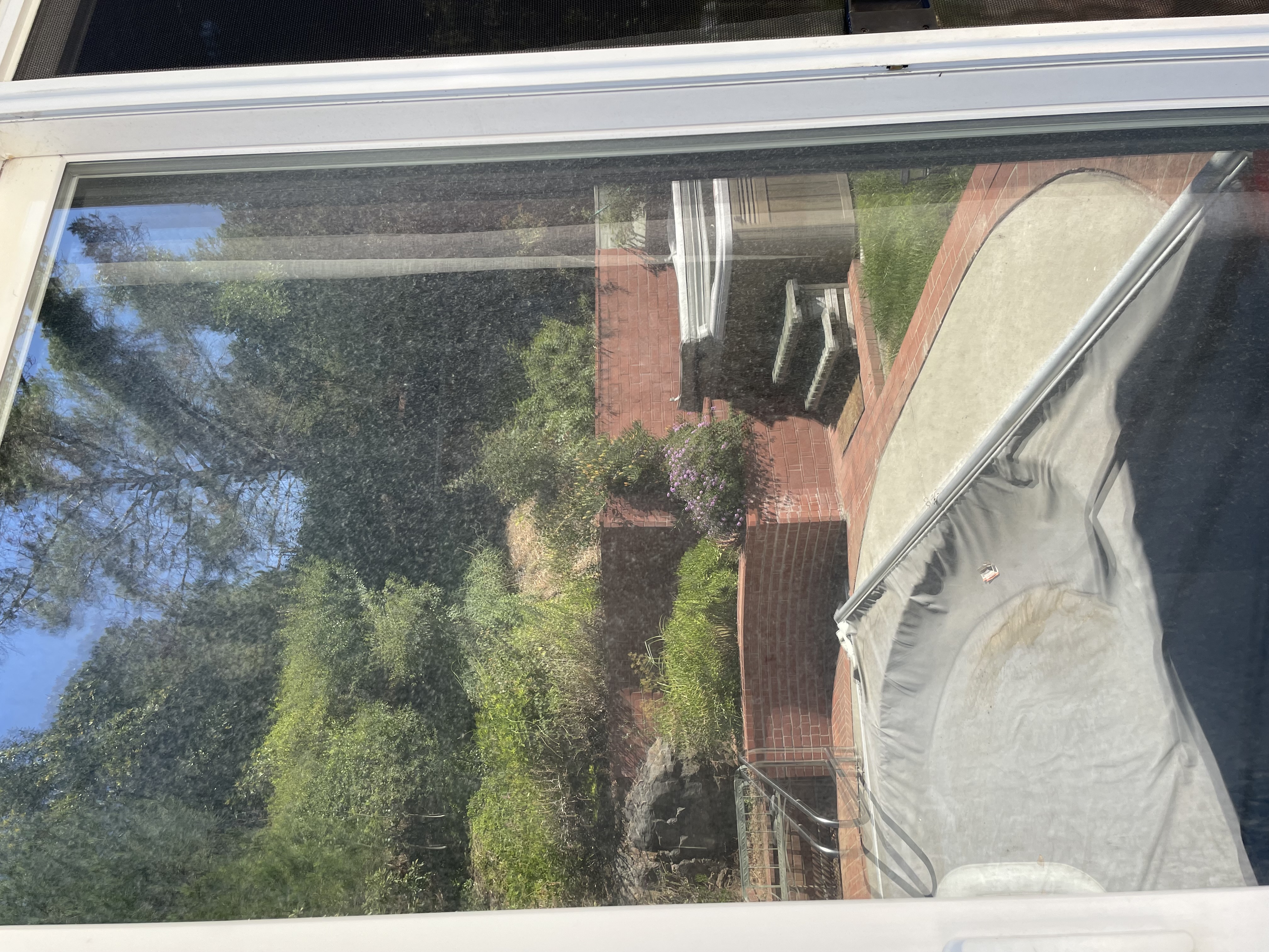Same sliding door before Glass Boyz cleaning - with water spots, streaks, and hazy buildup obscuring the view